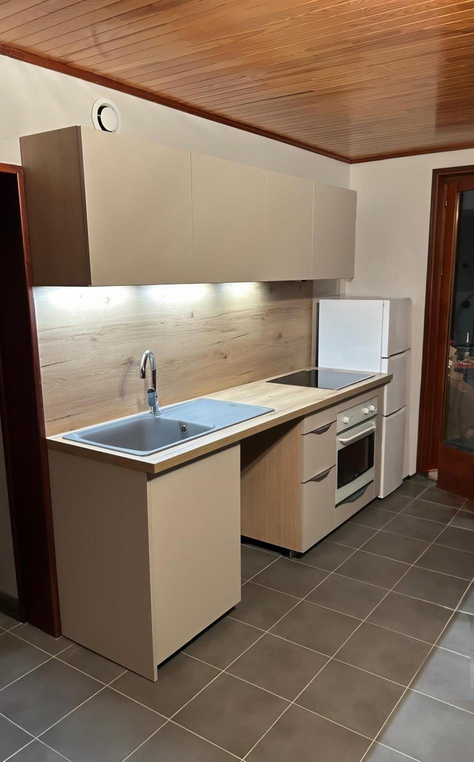 Cuisine rénovée avec façades bois, plan de travail bois et plafond en lambris dans un chalet du Briançonnais